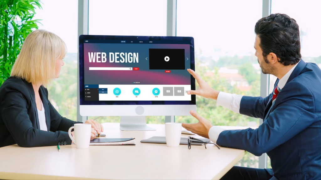 man and woman looking at website design on a pc