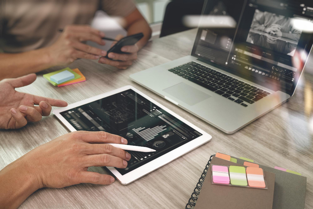 people working on website design on a tablet and a laptop